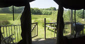View through Welcombe safari tent at Berridon Farm. Relax on the outdoor seating and enjoy the beautiful views