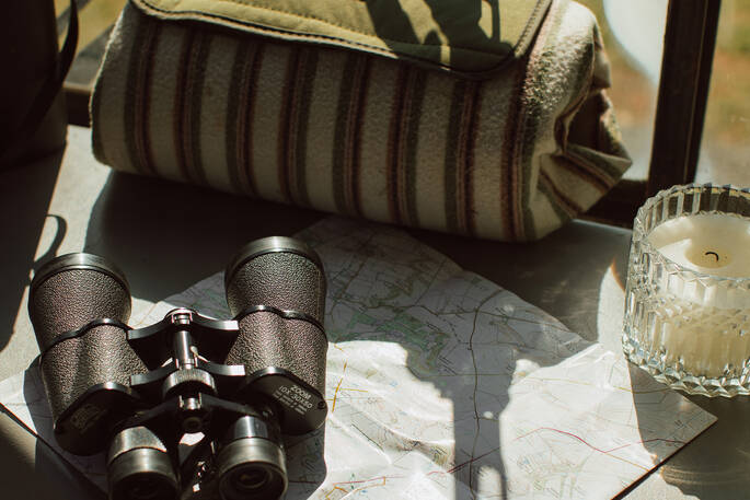 Binoculars, picnic blanket and map is provided