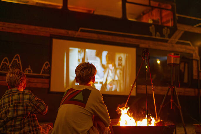 Set up your favourite movie on the projector and watch it sitting by the firepit