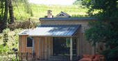 Exterior of GoGreen cabin with outdoor BBQ and large decking at GoGreen holidays in Dordogne, France 
